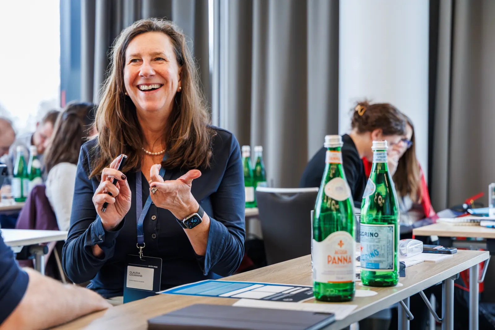 Teilnehmerin lacht im Austausch am Tisch