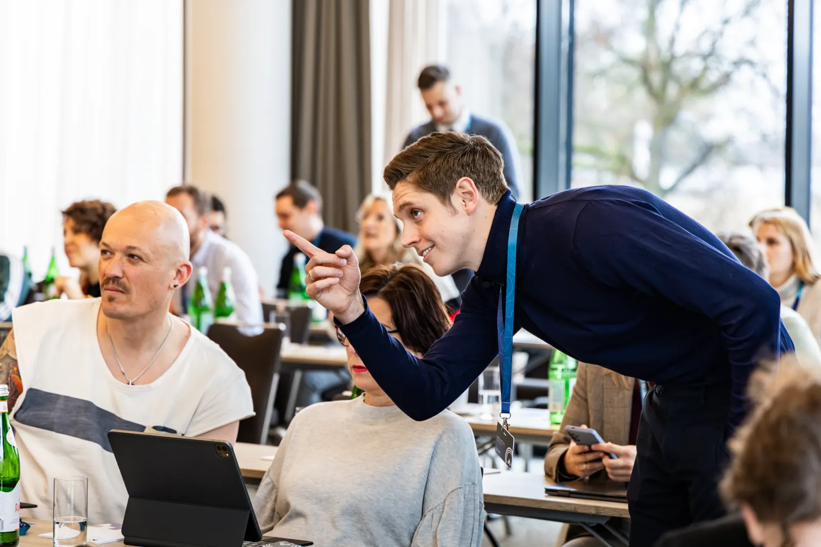 Redner beugt sich im Saal zu einer Teilnehmerin